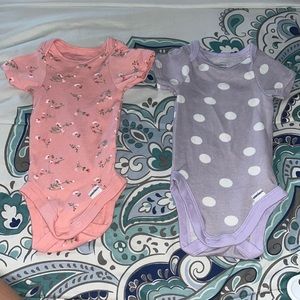 onesie with flowers and the second onesie with polkadots, bother are 100% cotton